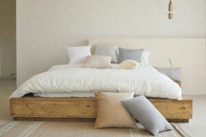 Bed on palettes with white bedding and cushions